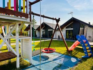 a playground in a yard with a swing at Domki na Rozanej in Rowy