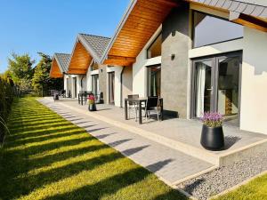 a patio of a house with a table and chairs at Domki na Rozanej in Rowy