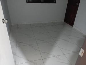 a room with a white tiled floor and a door at Hopesy's in Port Vila