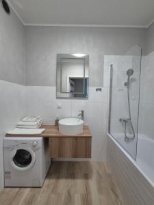 a bathroom with a washing machine and a sink at Apartament Centrum z darmowym podziemnym parkingiem in Stargard
