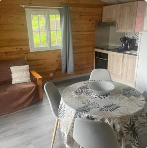 kuchnia ze stołem i krzesłami w pokoju w obiekcie La foret des hérissons w mieście Longessaigne