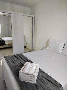 Prime Beach house Aracaju في أراكاجو: سرير أبيض مع منشفتين مطويتين عليه