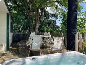 patio z krzesłami, stołem i wanną w obiekcie La foret des hérissons w mieście Longessaigne