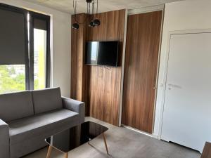a living room with a couch and a tv on a wall at Magnolia Loft Apartments in Wrocław