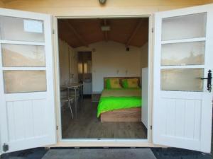 a bedroom with a bed through a door at CASUTA La Amy in Pangarati