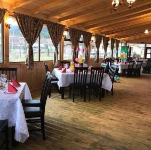a dining room with tables and chairs in a restaurant at CASUTA La Amy in Pangarati