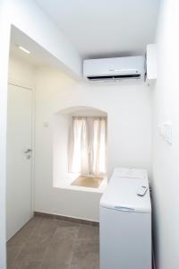 Charming Apartment in The Old Town في بودفا: مطبخ ابيض مع ثلاجة ونافذة +6 صور