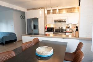 a kitchen with a table and chairs in a room at Central Cosy Appartement 3 chambres Levis Centre in Lévis