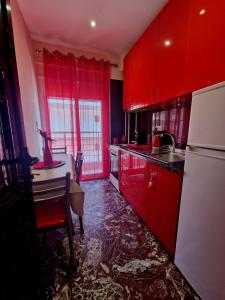 a red kitchen with a table and a refrigerator at Apartmani Vesna Luxury & Michel ap 9 in Paralia Katerinis