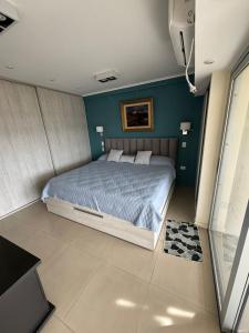 Un dormitorio con una cama con una pared azul. en Luxury apartment, en San Miguel de Tucumán