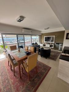 Un comedor con mesa y sillas y una sala de estar. en Luxury apartment, en San Miguel de Tucumán