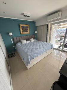 Un dormitorio con una cama con una pared azul. en Luxury apartment, en San Miguel de Tucumán