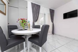 ein Esszimmer mit einem weißen Tisch und Stühlen in der Unterkunft Apartment in Vrbnik - Insel Krk 36871 in Vrbnik