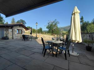 a patio with an umbrella and tables and chairs at Posada Campa in Sierra de Ibio +18 photos