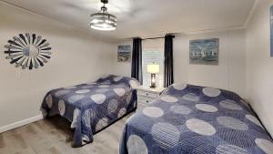 a bedroom with two beds and a mirror on the wall at Island Club #95 in Put-in-Bay