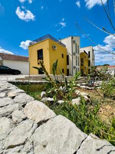a stone path in front of a yellow building at Adriatic Dream in Tivat