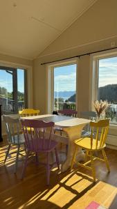 a room with a table and chairs and windows at Cabin by the lake with 3 bedrooms in Kvam