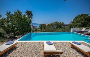 a swimming pool with two chaise lounge chairs and a swimming poolvisor at Amazing Home In Crikvenica in Crikvenica