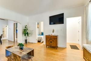 a living room with a table and a tv on a wall at 2 Mi to Rainbow Beach Park South Side Charmer! in Chicago