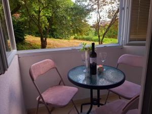 a table with a bottle of wine and two chairs at Urban Elegance Apartment Sarajevo in Sarajevo