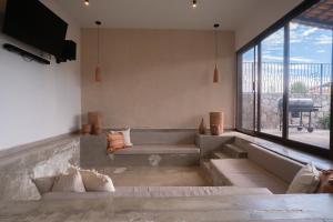 a living room with a bench and a large window at Casa Xanu in Tapalpa