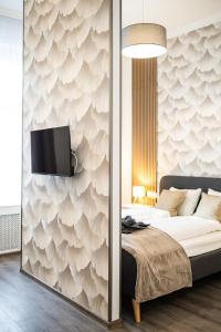 a bedroom with a bed and a tv on a wall at Stylish Natural Studio Central Budapest in Budapest