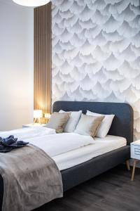 a bedroom with a large bed with a wall with waves at Stylish Natural Studio Central Budapest in Budapest