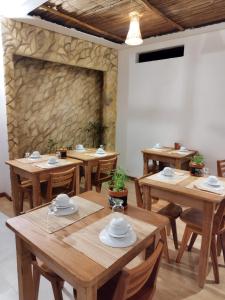 a dining room with wooden tables and a stone wall at Japaratinga Suites in Japaratinga +55 photos