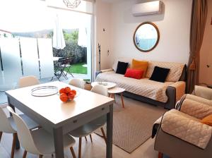 una sala de estar con un sofá y una mesa en Casas turísticas Lar Jardín - Parking privado, en Santiago de Compostela