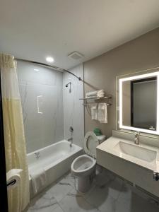 Un baño con bañera, inodoro y lavabo. en Texarkana Inn, en Texarkana