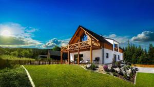 a house with a wooden roof and a yard at Chalet Oasis - Luxury 5-Bedroom Chalet with Panoramic Views in Huty +65 photos