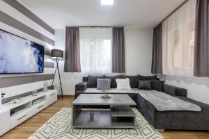 a living room with a couch and a tv at Apartman Aki in Bele Vode