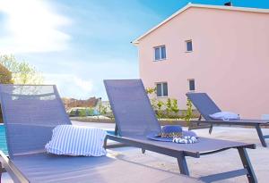 ein paar Stühle auf einer Terrasse in der Unterkunft Apartments in Cizici - Insel Krk 31083 in Čižići + 8 Fotos