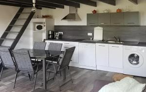 une cuisine avec une table et des chaises ainsi qu'un lave-linge. dans l'établissement Maison Avec Piscine, à Malaucène