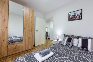 Un dormitorio con una cama y un espejo grande. en Apartman Aki, en Bele Vode 1 foto más