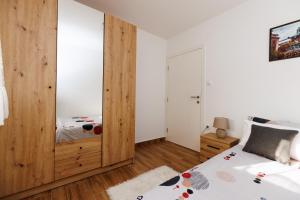 a bedroom with a bed and a wooden closet at Apartman Aki in Bele Vode