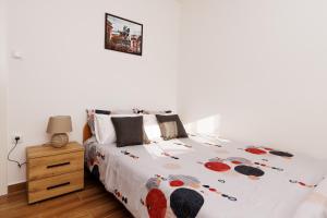a white bedroom with a bed and a night stand at Apartman Aki in Bele Vode +1 photo