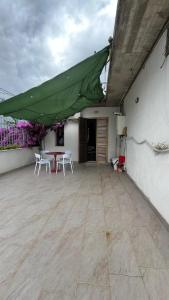a patio with white chairs and a green roof at Casamare in Roseto degli Abruzzi