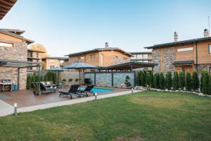 a patio with two chairs and a table and a pool at Aqua Thermal Villa Banya in Banya