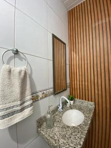 イポジュカにあるSuíte Maracaの洗面台と鏡のあるバスルーム