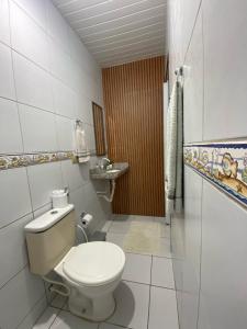 イポジュカにあるSuíte Maracaのトイレと洗面台のある小さなバスルーム +1枚の写真