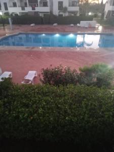 a view of a swimming pool with two lawn chairs at Saidia Marina ap7 les Jardins de la Medina in Cherarba