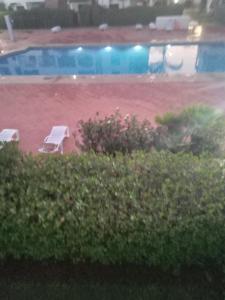 two chairs and a swimming pool in a yard at Saidia Marina ap7 les Jardins de la Medina in Cherarba