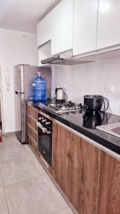 a kitchen with two pots and pans on the stove at Departamento Familiar en primer piso in Trujillo
