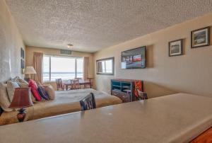 a hotel room with a bed and a living room at Comfy Second Floor Beachfront Condo - Sleeps 4 - Pool and Sauna in Lincoln City