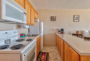 a kitchen with a stove and a white refrigerator at Comfy Second Floor Beachfront Condo - Sleeps 4 - Pool and Sauna in Lincoln City