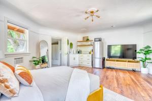 a bedroom with a white bed and a tv at Forest Studio Oasis - Mile from Multnomah Village in Portland