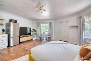 a white bedroom with a bed and a television at Forest Studio Oasis - Mile from Multnomah Village in Portland
