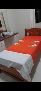 ein Bett mit einer roten Decke mit Blumen drauf in der Unterkunft Casa de temporada in São Raimundo Nonato + 5 Fotos