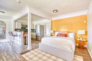 a bedroom with a white bed and a kitchen at Forest Studio Retreat - Near Multnomah Village in Portland